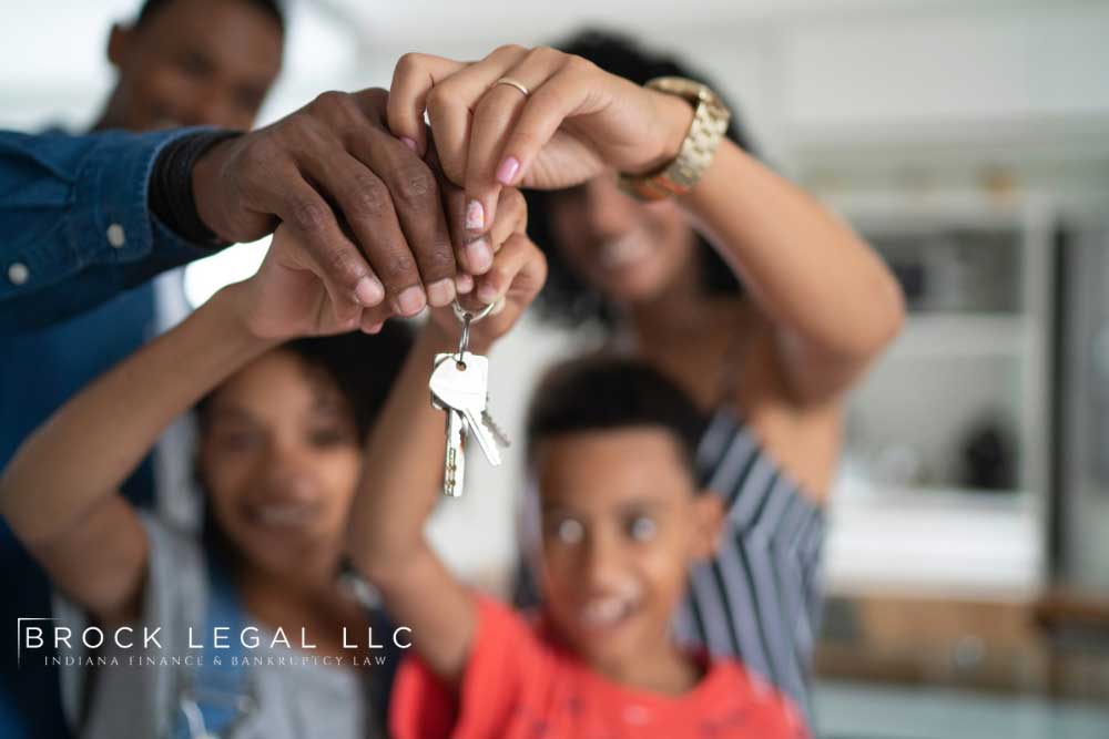 Happy family holding keys to their new home, representing the importance of homestead exemption in bankruptcy for Brock Legal LLC.