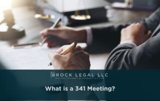 A professional Indiana bankruptcy lawyer consults with a client at a wooden desk, discussing legal documents with a pen in hand, symbolizing trusted legal consultation and financial recovery services.| Brock Legal, LLC
