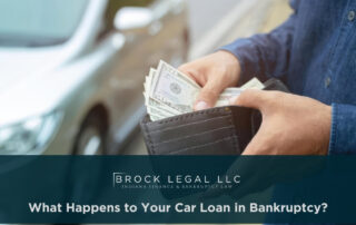A person in a blue shirt holds an open wallet with cash, standing near a silver car. This image represents financial recovery discussions with a trusted Indiana bankruptcy lawyer at Brock Legal, LLC.| Brock Legal, LLC